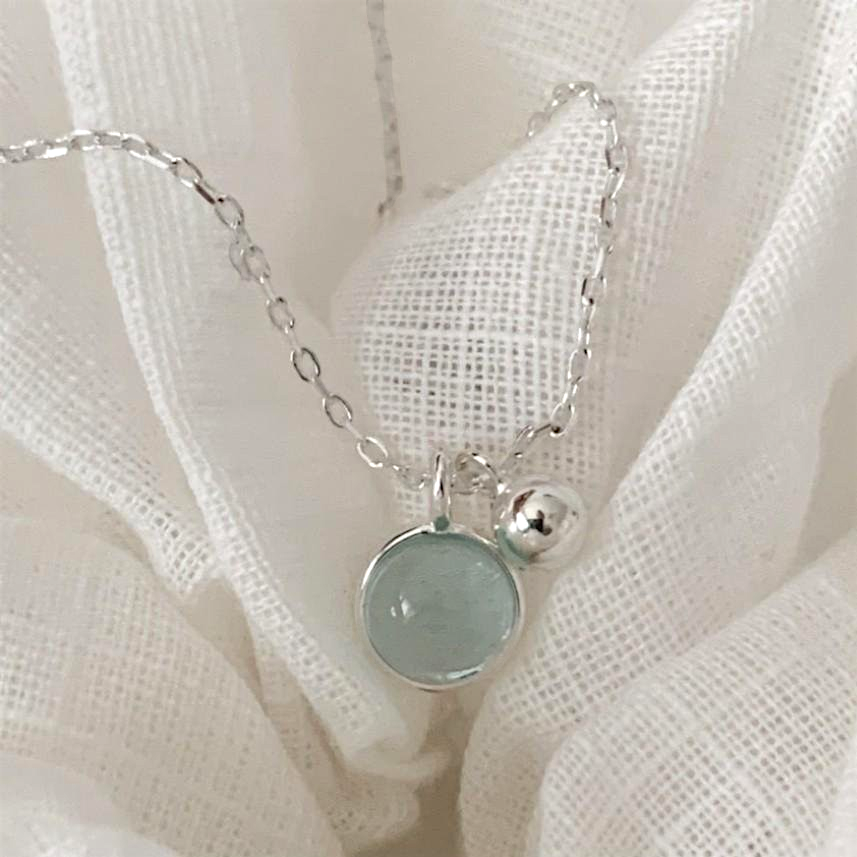 Amara Jewels sterling silver necklace with a round aqua charm and a polished silver bead.