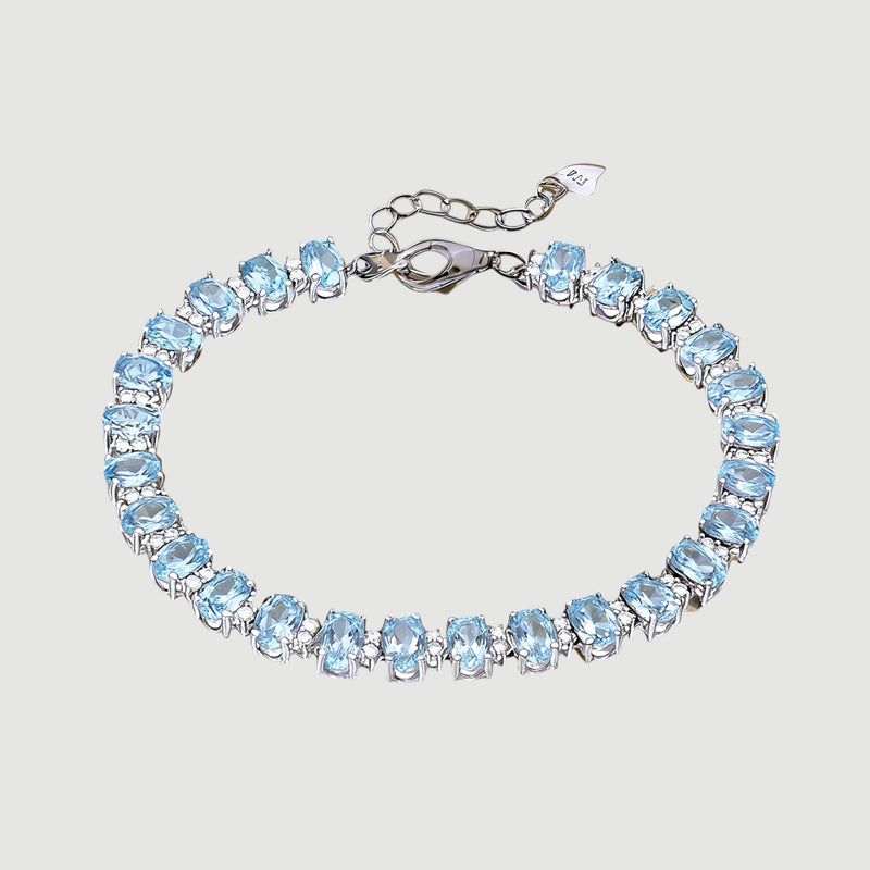 Amara Jewels blue topaz tennis bracelet in 925 sterling silver with adjustable clasp. Oval cut stones.