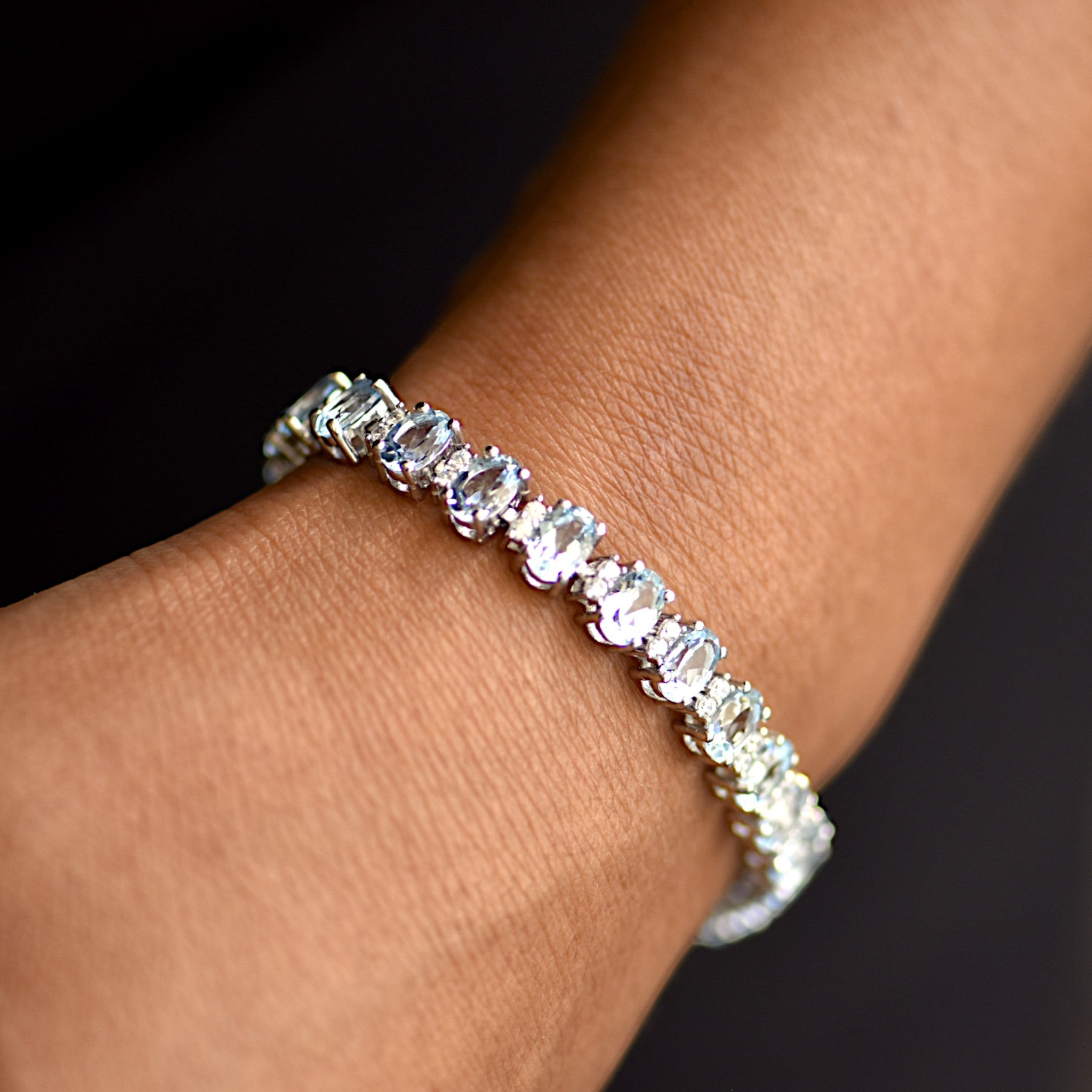 Amara Jewels blue topaz tennis bracelet in 925 sterling silver with adjustable clasp. Oval cut stones.