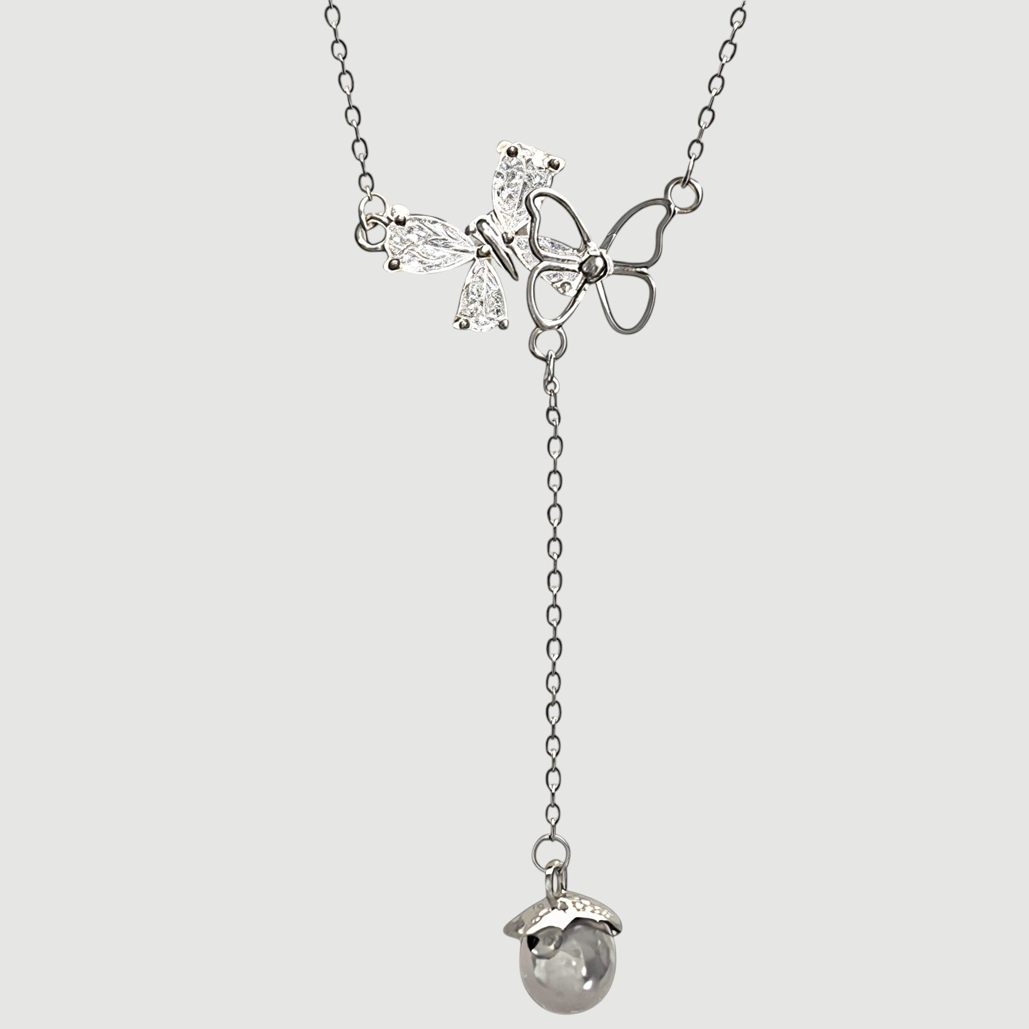 Amara Jewels sterling silver necklace with butterfly pendant adorned with cubic zirconia and an acorn charm.