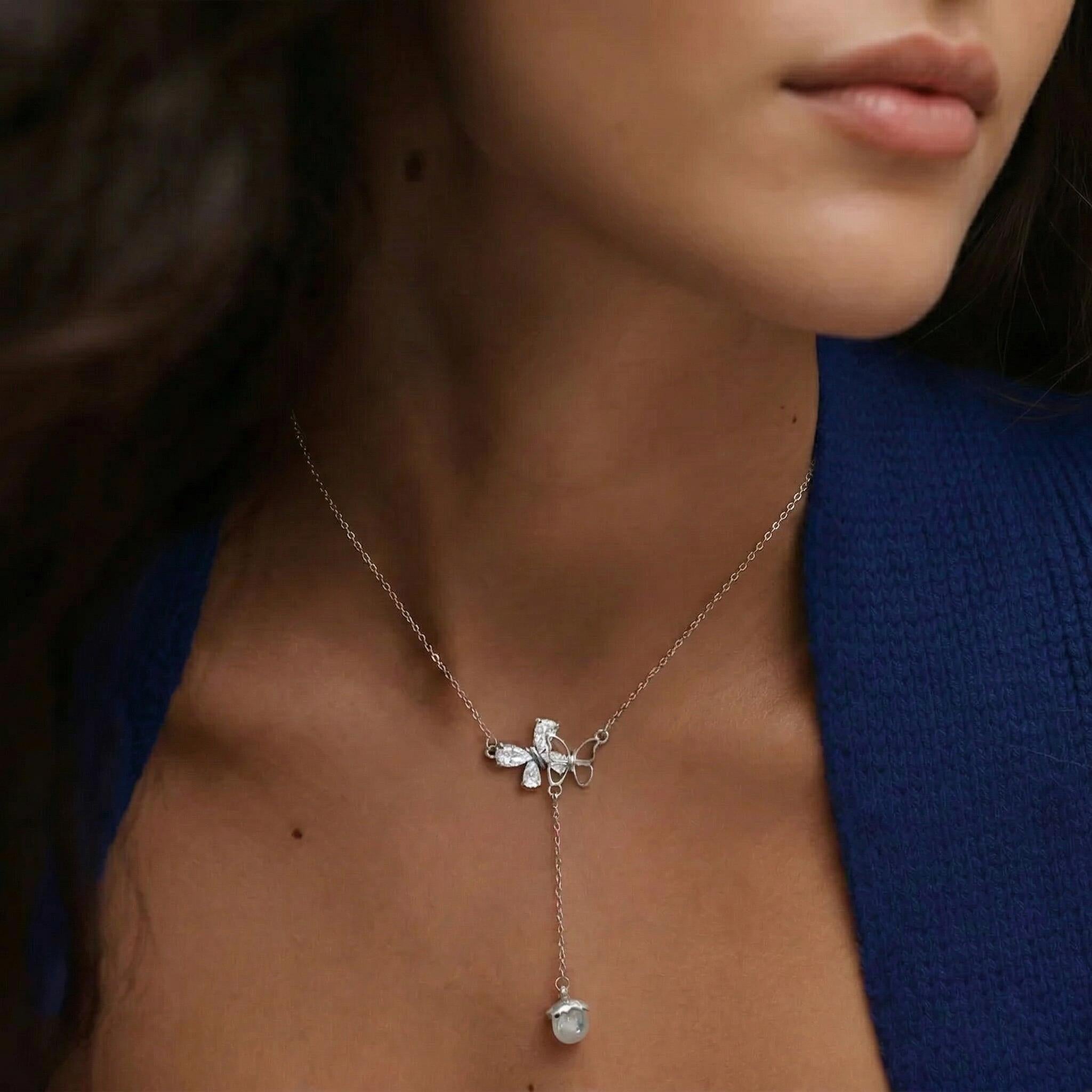 Amara Jewels sterling silver necklace with butterfly pendant adorned with cubic zirconia and an acorn charm.