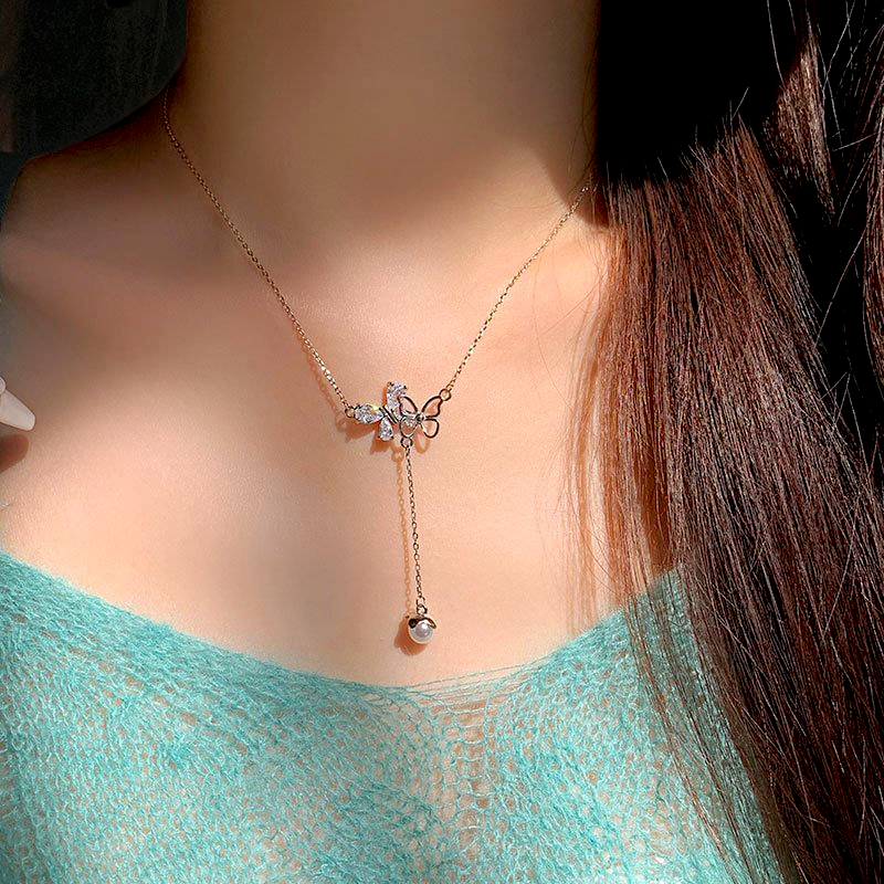 Amara Jewels sterling silver necklace with butterfly pendant adorned with cubic zirconia and an acorn charm.