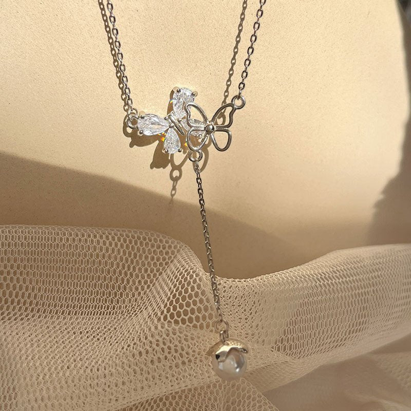Amara Jewels sterling silver necklace with butterfly pendant adorned with cubic zirconia and an acorn charm.