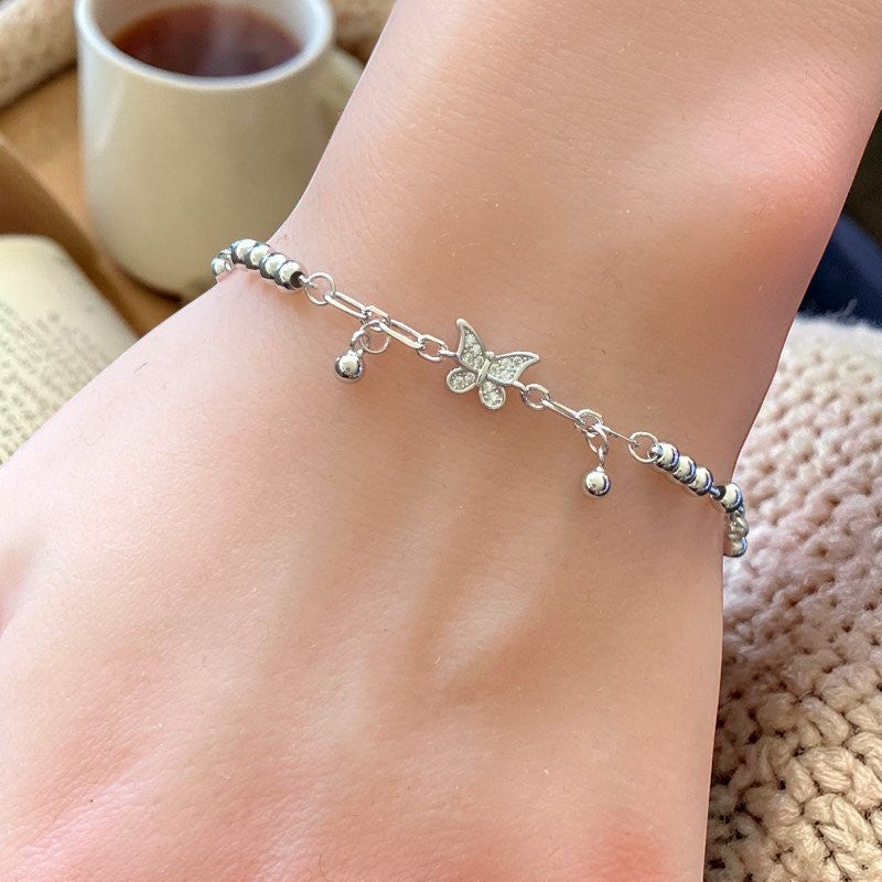 Amara Jewels sterling silver bracelet with delicate butterfly charms and polished silver beads, adjustable clasp.