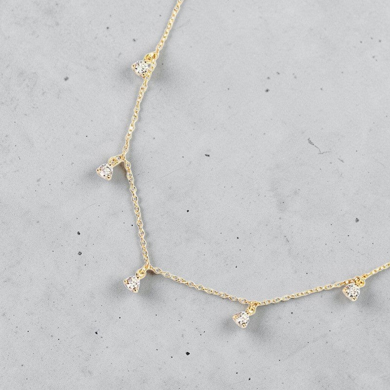 Amara Jewels gold-plated sterling silver necklace with five small crystal pendants spaced along a delicate chain.