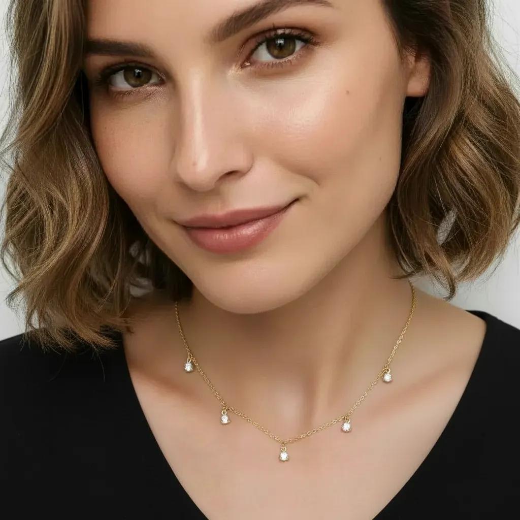 Amara Jewels gold-plated sterling silver necklace with five small crystal pendants spaced along a delicate chain.