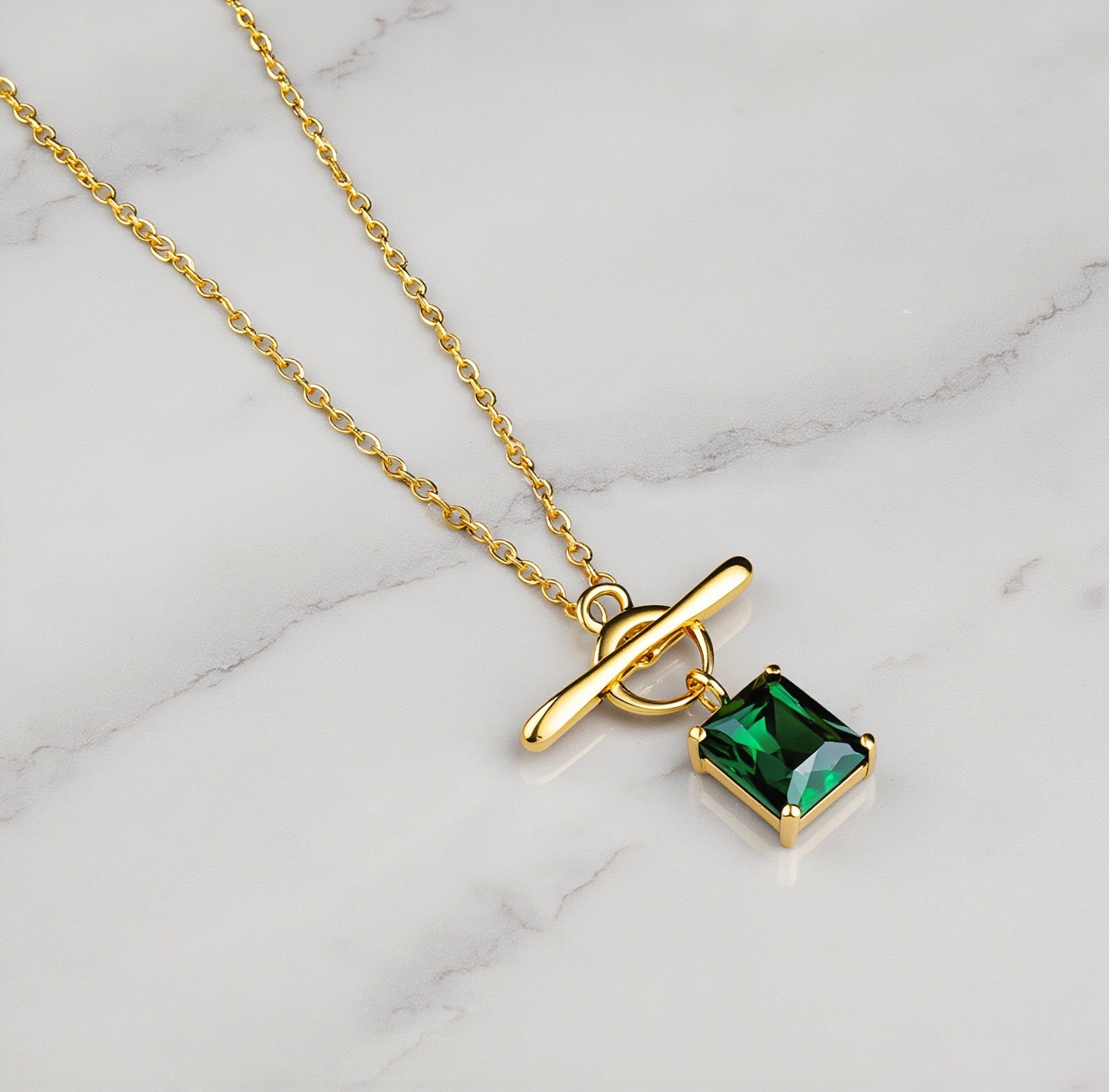 Amara Jewels gold vermeil sterling silver necklace with a rectangular emerald-green gemstone and toggle clasp.