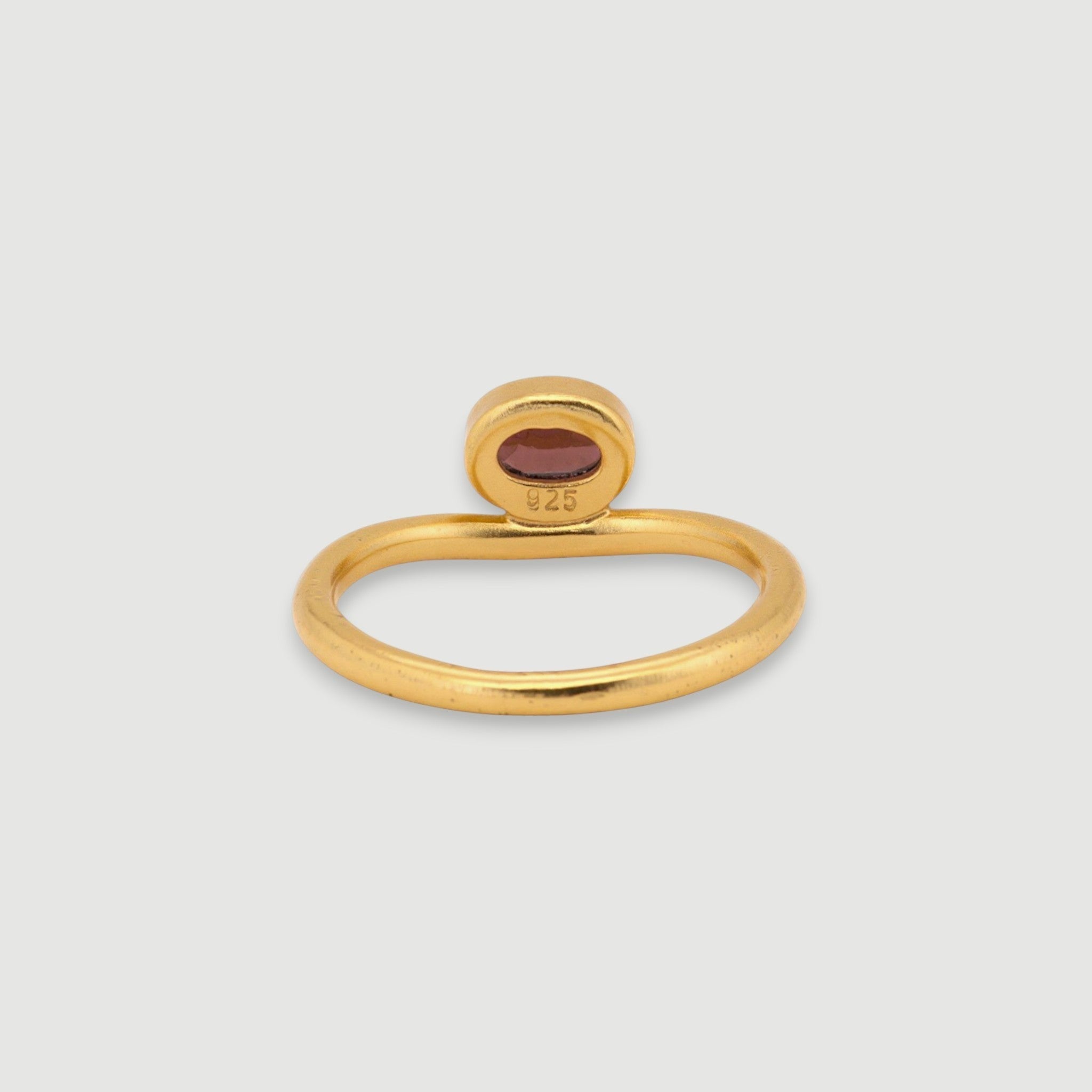 Amara Jewels 18K gold vermeil sterling silver ring with a bezel-set oval garnet gemstone. Minimalist design.