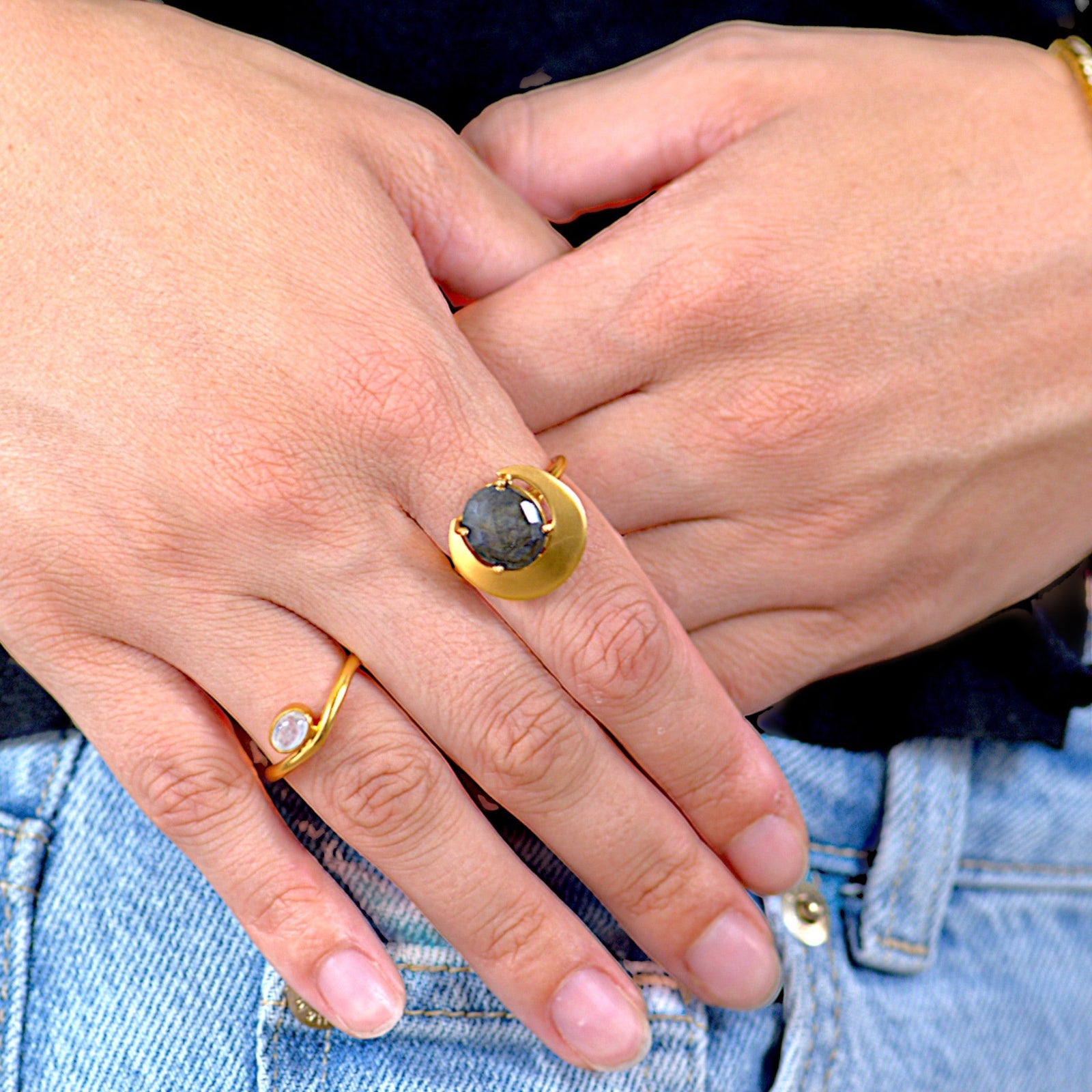 Amara Jewels gold ring with a dark grey gemstone in a crescent bezel on a 925 sterling silver band with 18k gold vermeil.