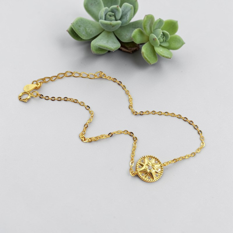 Amara Jewels gold-plated sterling silver bracelet with a celestial compass charm adorned with cubic zirconia. Adjustable chain.