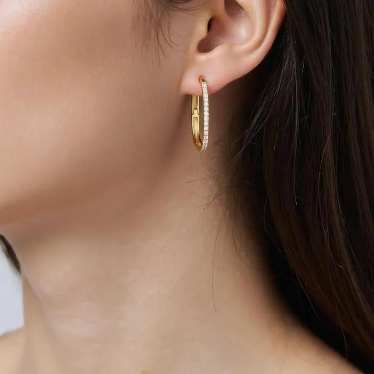 Amara Jewels gold-plated sterling silver oval hoop earrings with cubic zirconia accents.