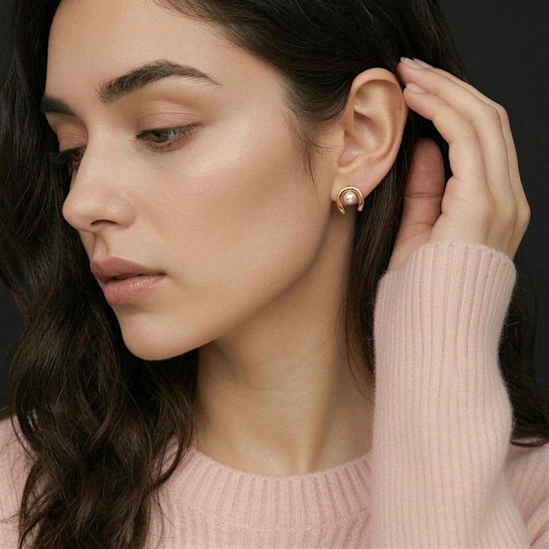 Amara Jewels gold plated sterling silver wave pearl stud earrings. Lustrous white pearls set in a modern wave design.