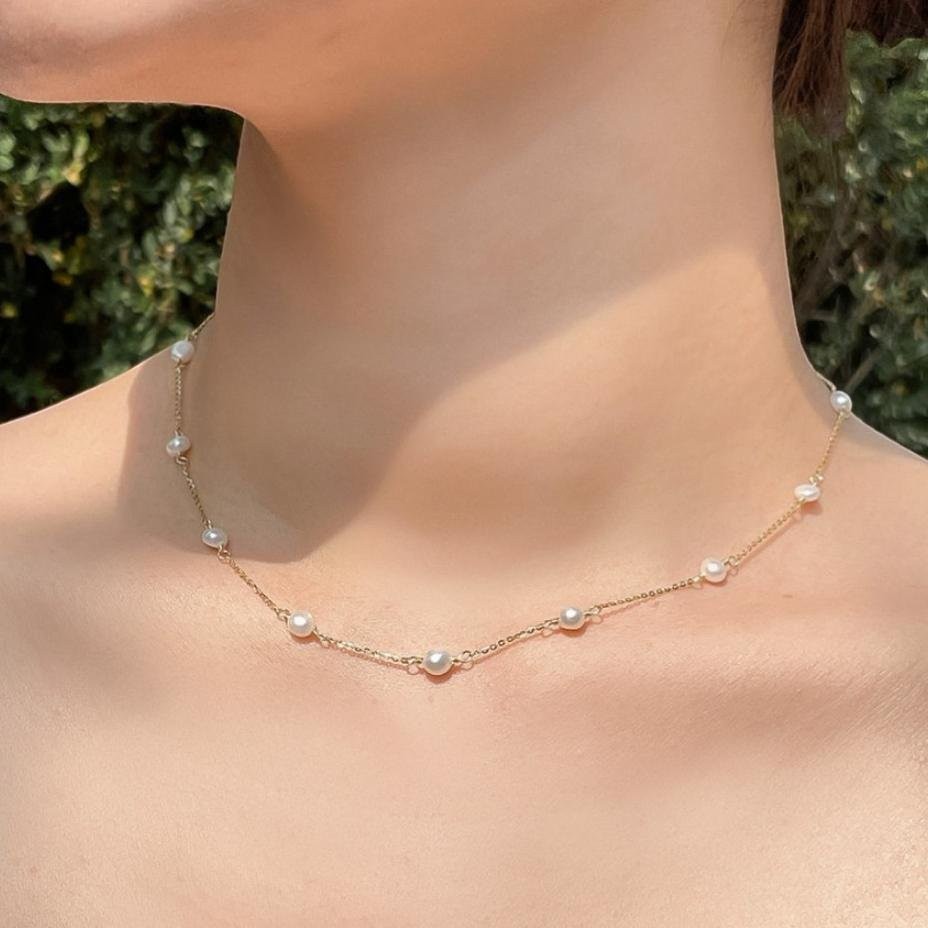 Amara Jewels 18K gold-plated sterling silver necklace with luminous pearl stations on a fine chain.