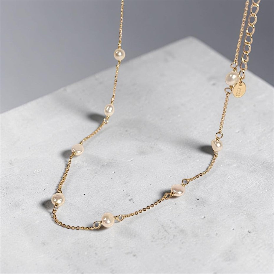Amara Jewels 18K gold-plated sterling silver necklace with luminous pearl stations on a fine chain.
