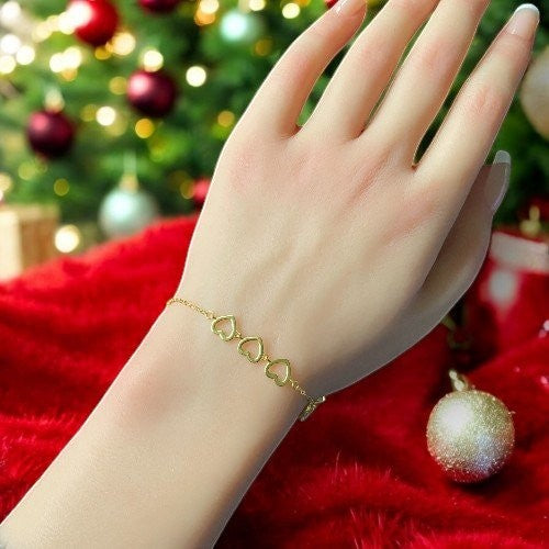 Amara Jewels gold-finished sterling silver bracelet with red enamel heart, cubic zirconia charm, and open hearts.