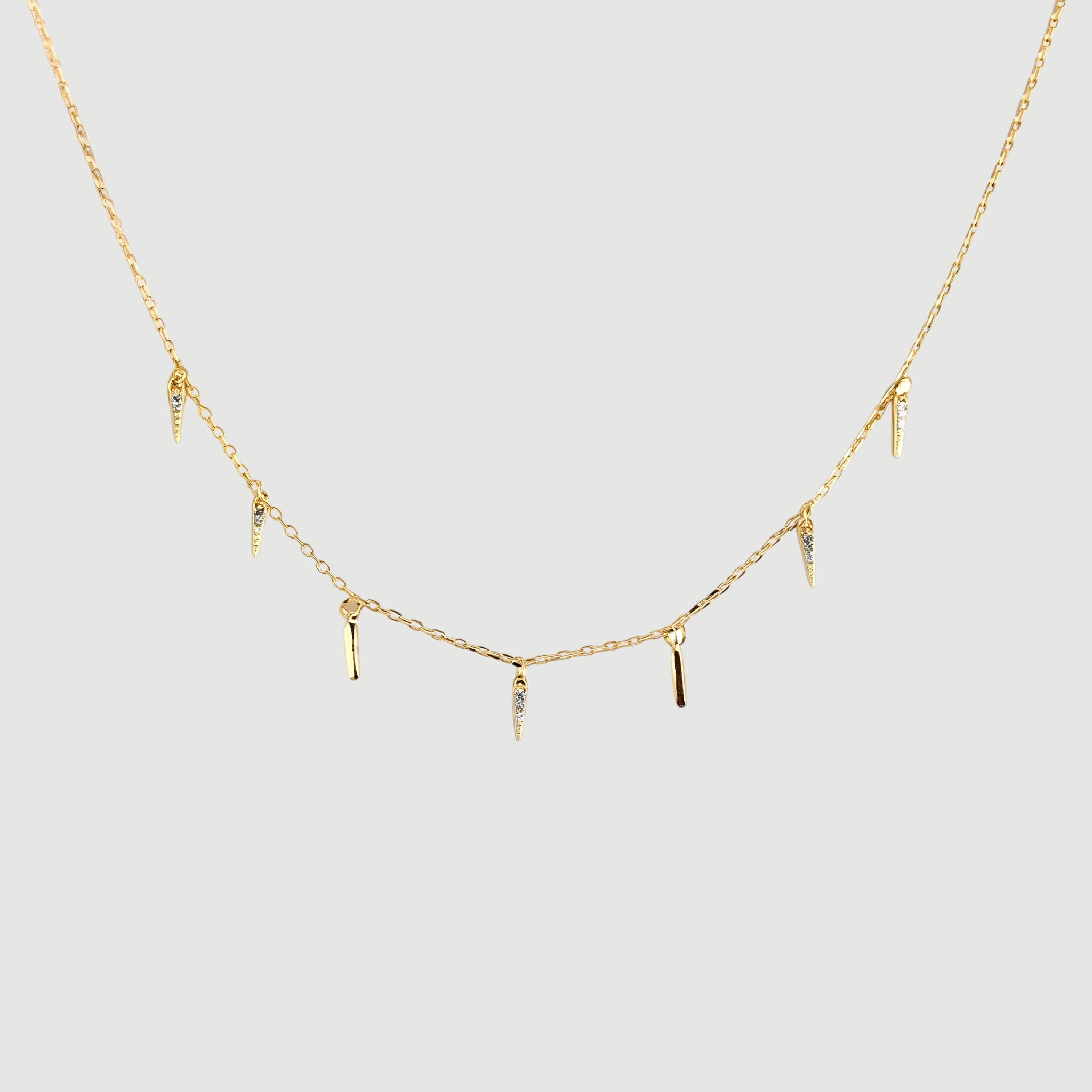 Amara Jewels gold-plated sterling silver necklace with dangling spike charms and small crystals.