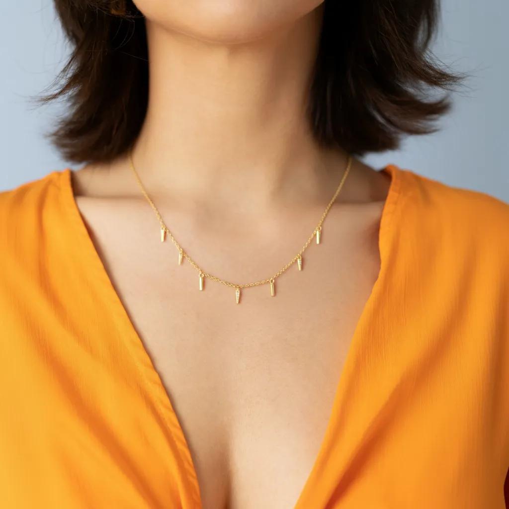 Amara Jewels gold-plated sterling silver necklace with dangling spike charms and small crystals.