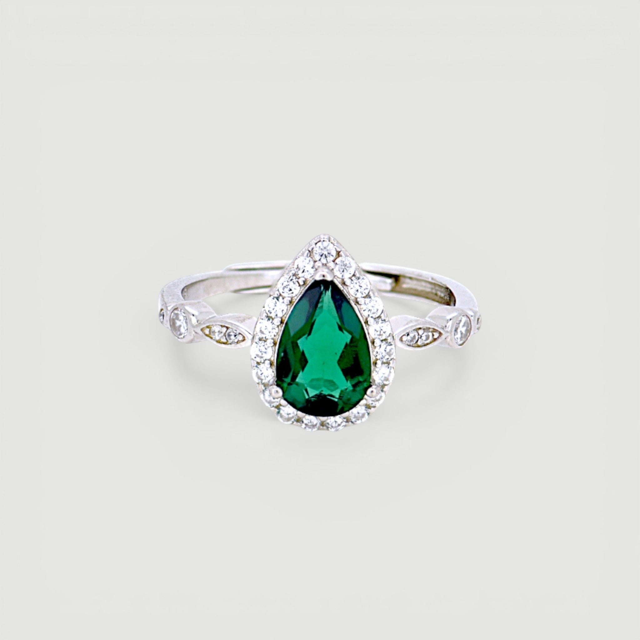 Amara Jewels sterling silver ring with a green teardrop gemstone surrounded by small clear stones. Intricate detailing on band.