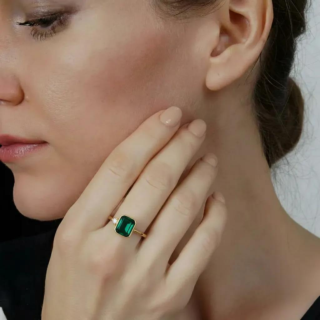 Amara Jewels gold-finish 925 sterling silver ring with rectangular emerald-green gemstone and cubic zirconia accent.