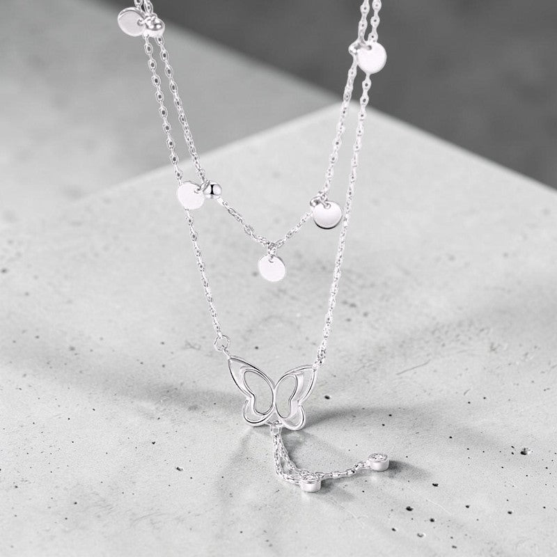 Amara Jewels double-layered sterling silver necklace with butterfly pendant and dangling crystals.