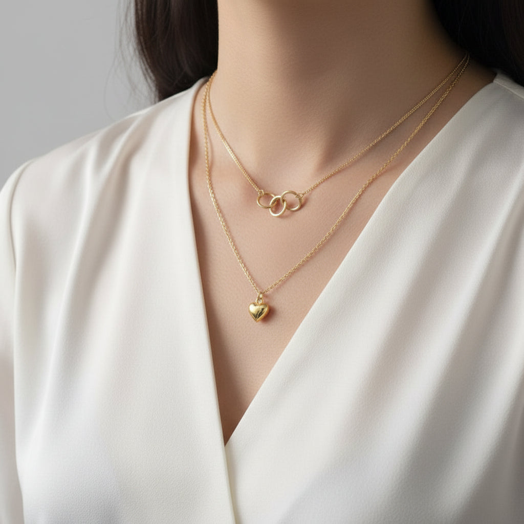 Amara Jewels gold-plated sterling silver layered necklace with heart and interlocking circles pendants.