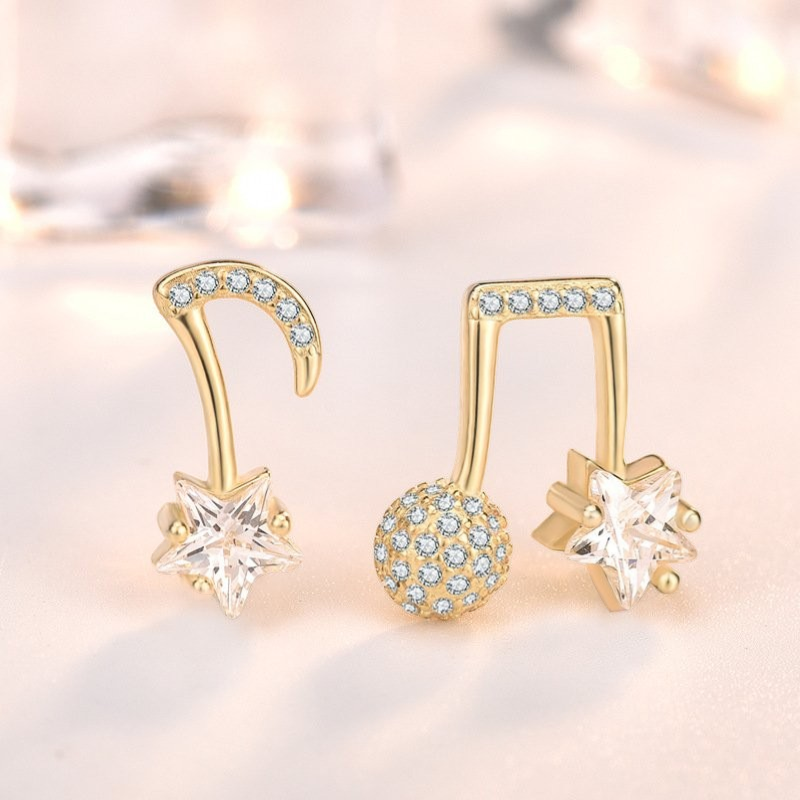Amara Jewels gold-plated sterling silver asymmetrical music note and star earrings with cubic zirconia.