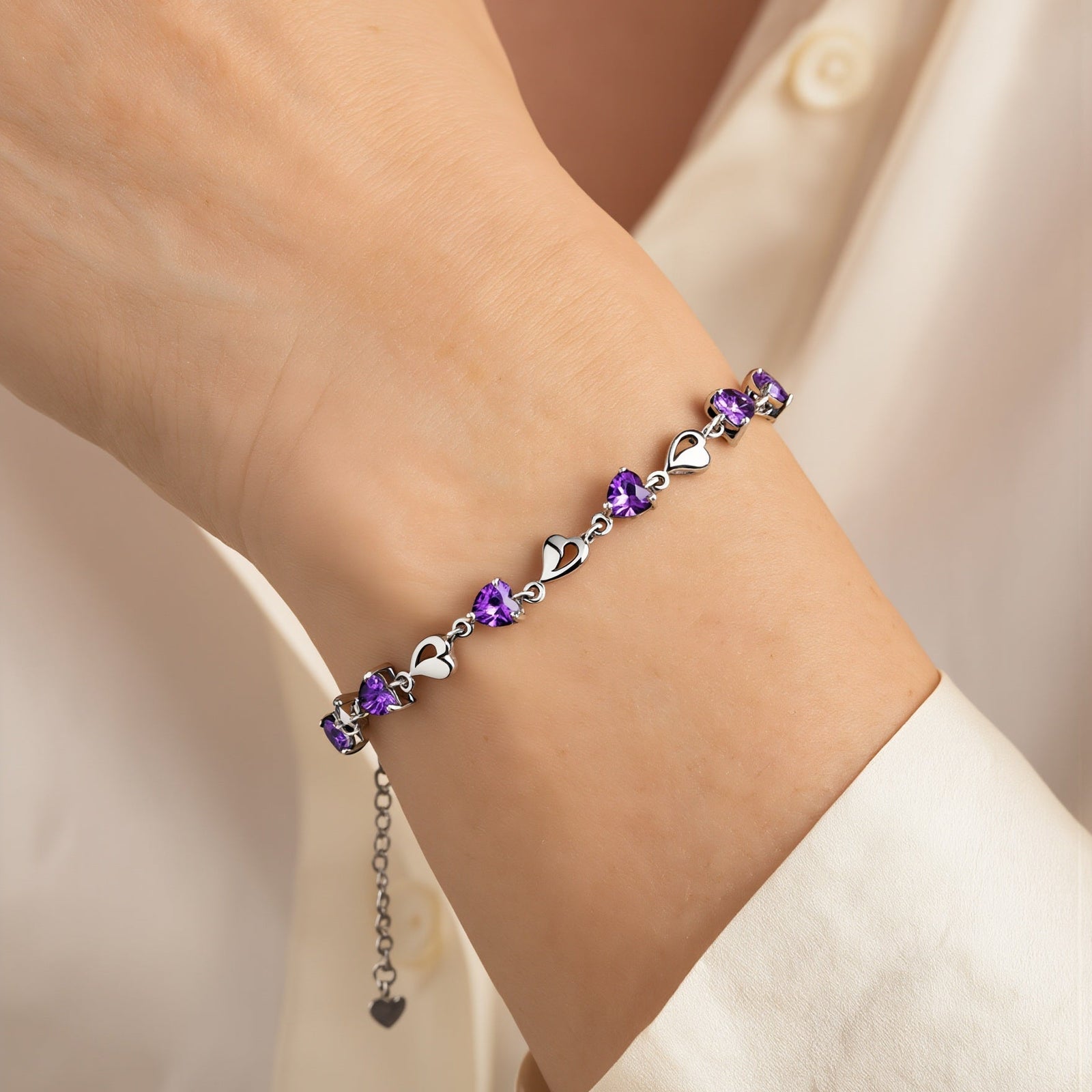 Amara Jewels sterling silver bracelet with purple heart-shaped links and shimmering stones.