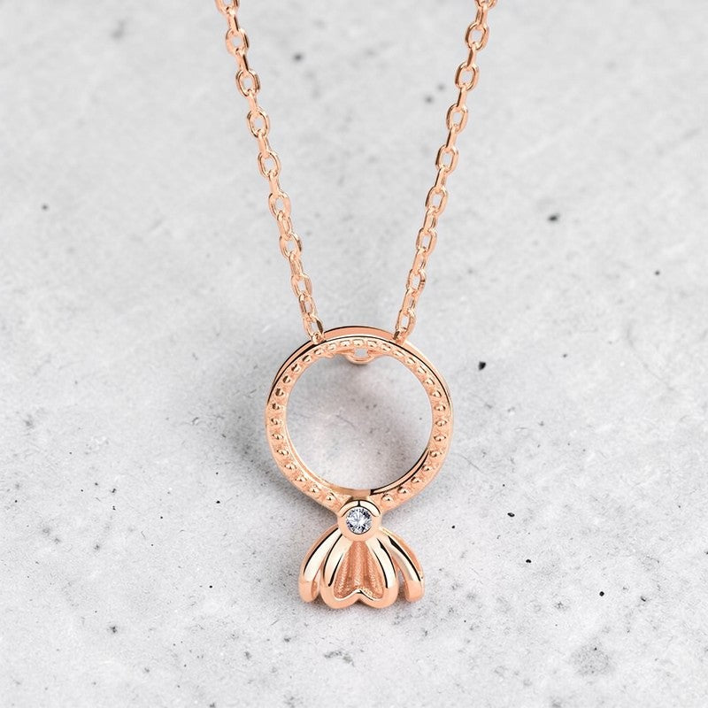 Amara Jewels rose gold plated sterling silver necklace with open circle pendant and flower drop charm with center stone.