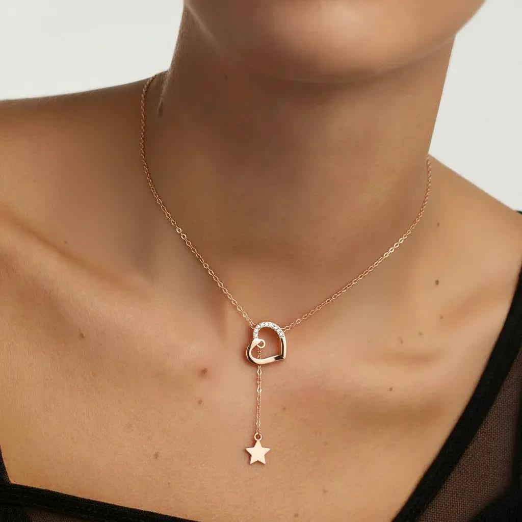 Amara Jewels rose gold tone necklace with heart pendant adorned with cubic zirconia and a dangling star charm.