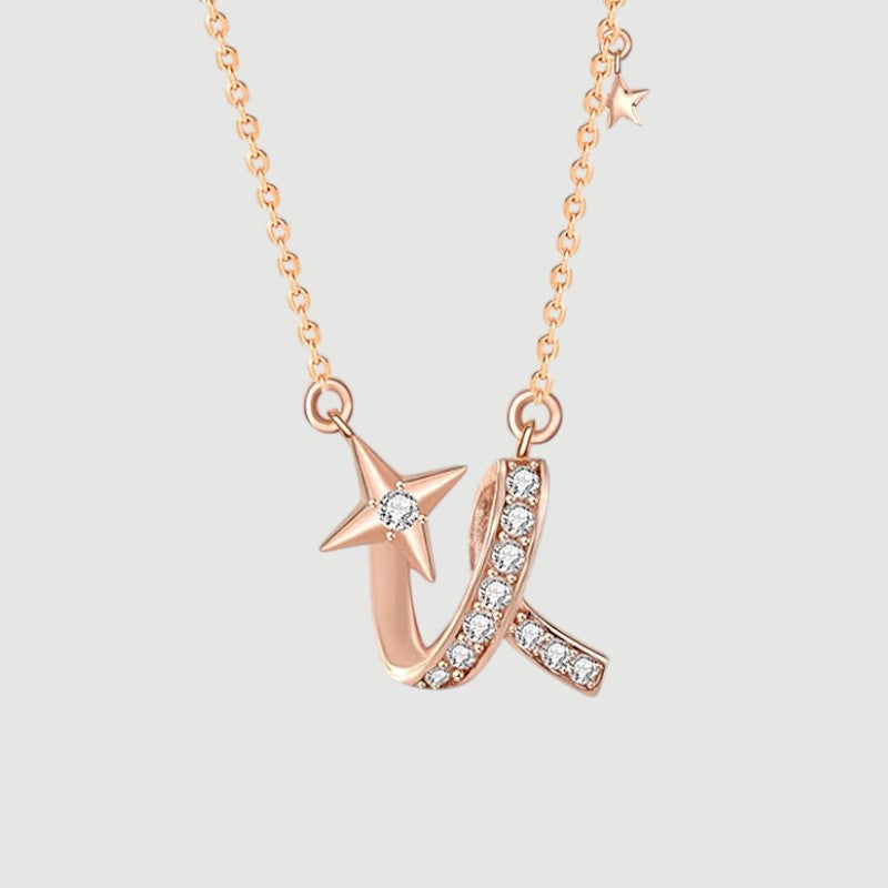 Amara Jewels rose gold necklace with a shooting star charm adorned with a diamond and a curved ribbon embellished with small diamonds.