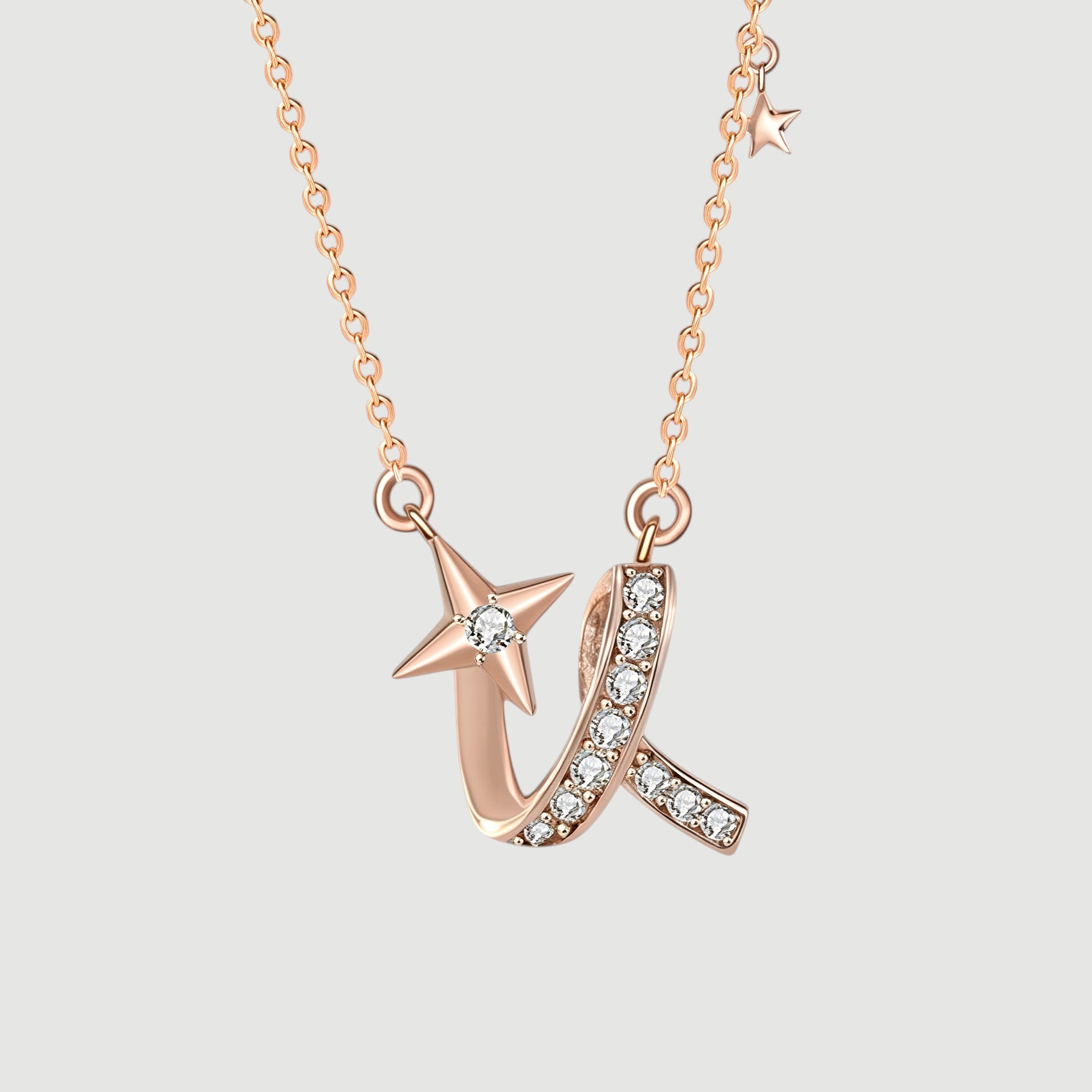 Amara Jewels rose gold necklace with a shooting star charm adorned with a diamond and a curved ribbon embellished with small diamonds.