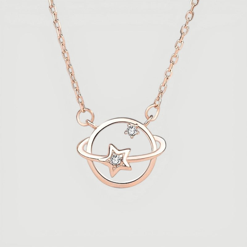 Amara Jewels rose gold plated 925 sterling silver necklace with a planet orbit and star design, accented with cubic zirconia.
