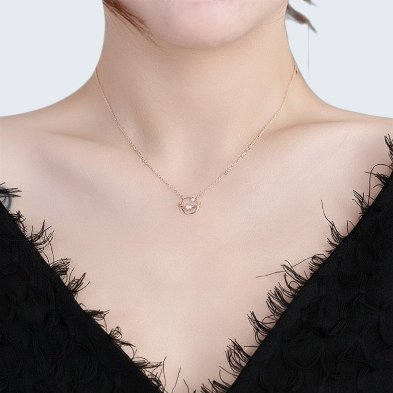 Amara Jewels rose gold plated 925 sterling silver necklace with a planet orbit and star design, accented with cubic zirconia.
