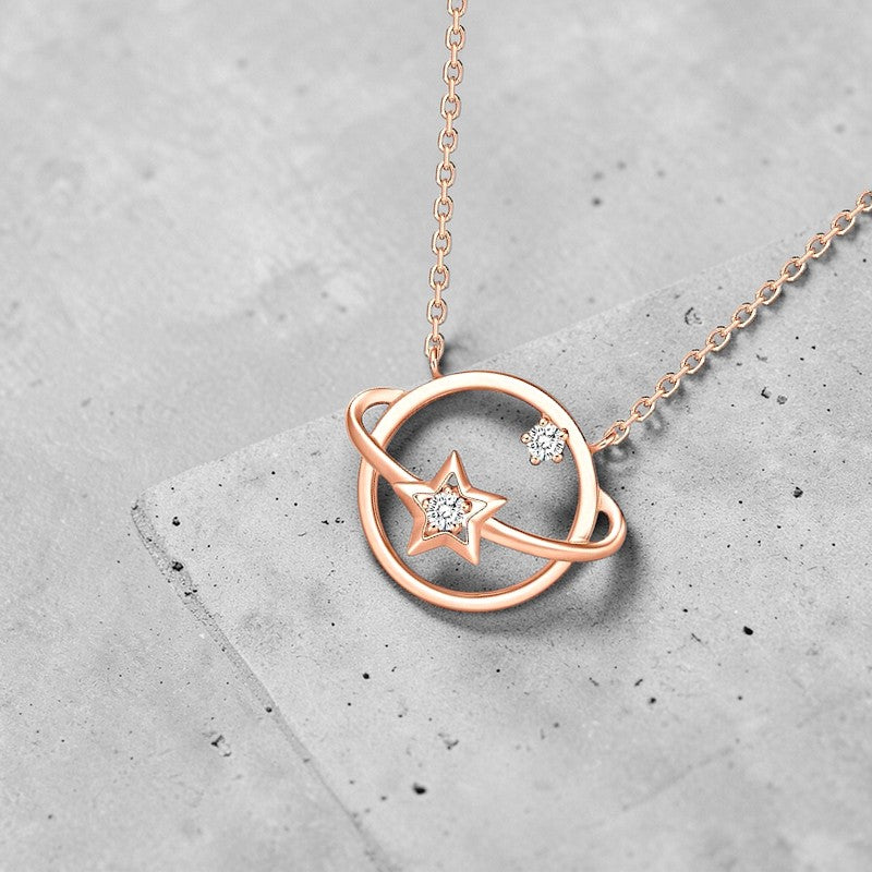 Amara Jewels rose gold plated 925 sterling silver necklace with a planet orbit and star design, accented with cubic zirconia.