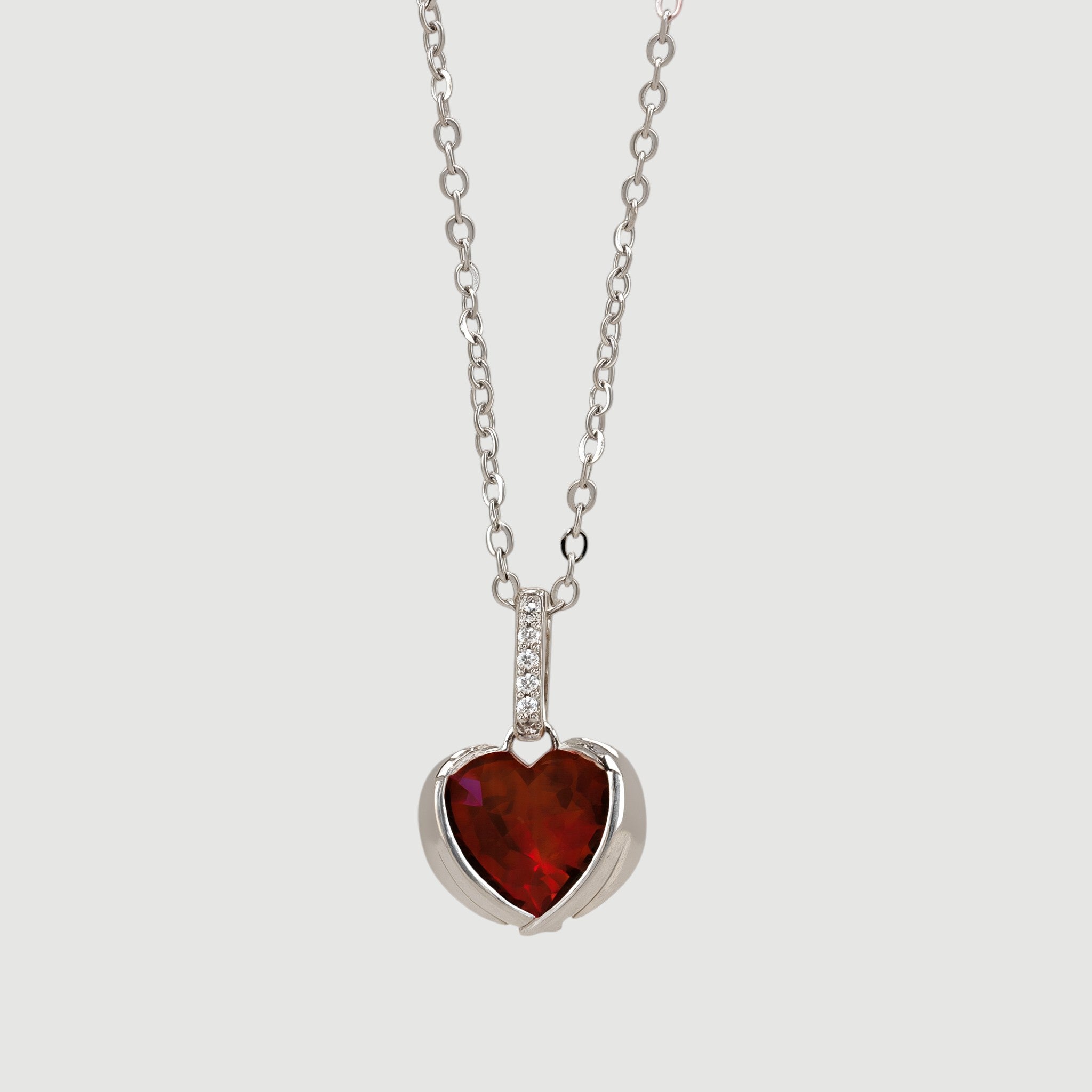 Amara Jewels sterling silver necklace with ruby red heart pendant and delicate chain, adorned with small crystals.