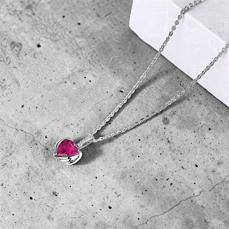 Amara Jewels sterling silver necklace with ruby red heart pendant and delicate chain, adorned with small crystals.