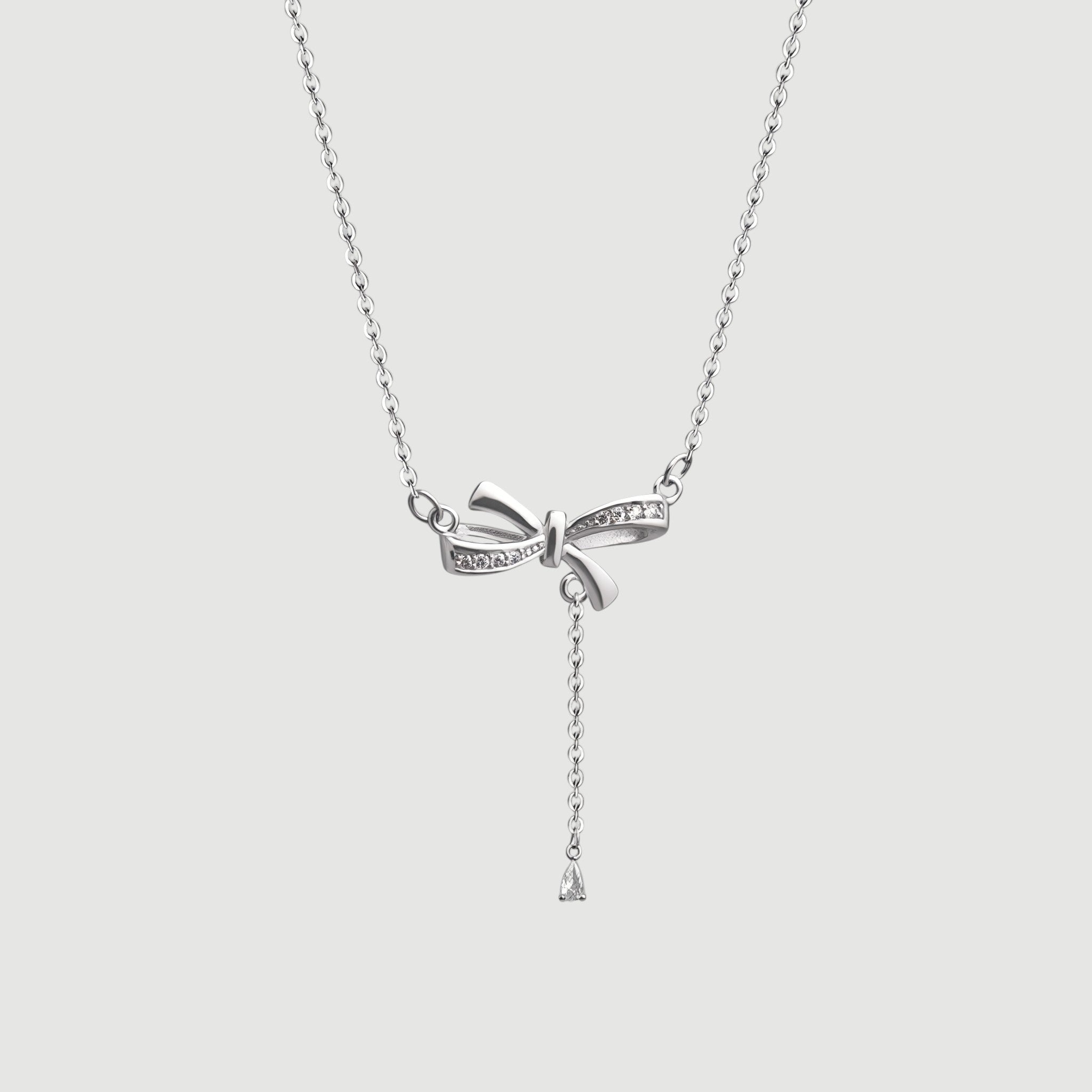Amara Jewels sterling silver bow pendant necklace with cubic zirconia accents and a dangling pear-shaped stone.