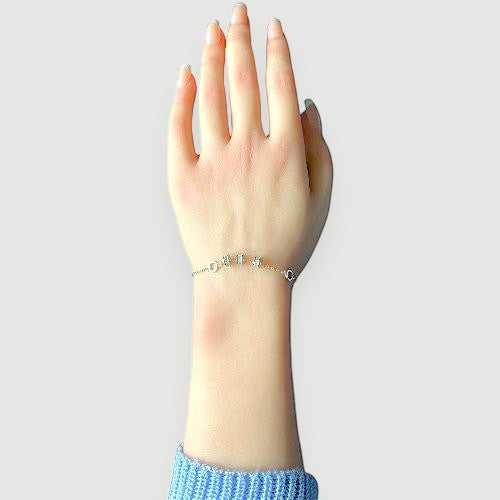 Amara Jewels 925 sterling silver bracelet with geometric charms and adjustable chain. Features circular and bar charms with baguette-cut stones.