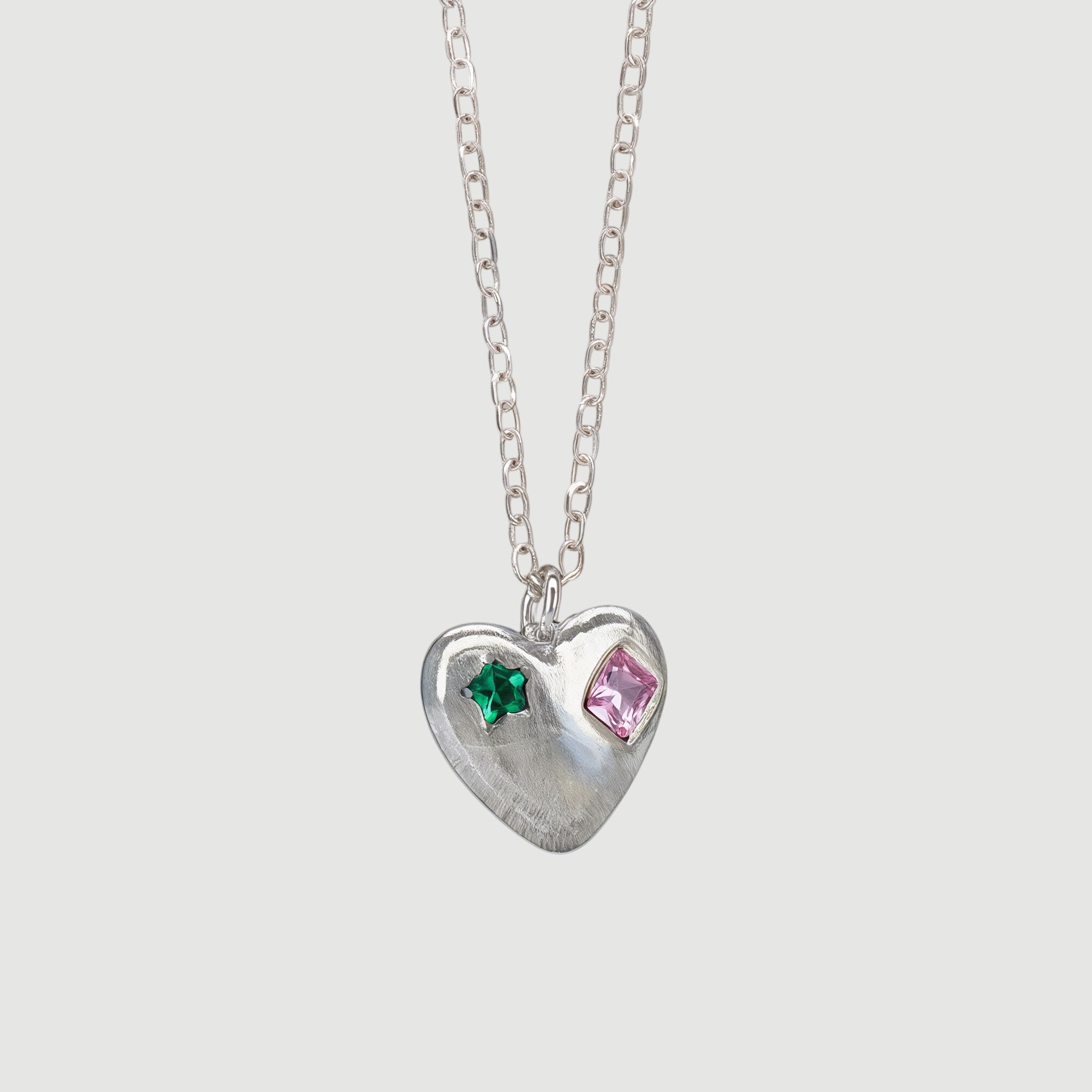 Amara Jewels sterling silver heart charm necklace with engraved red and green shapes.