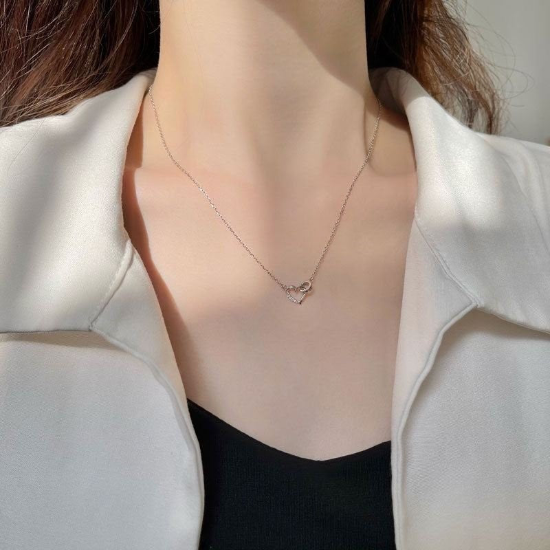 Amara Jewels silver 925 sterling necklace with a delicate heart pendant featuring crystal accents and an intertwined ring detail.