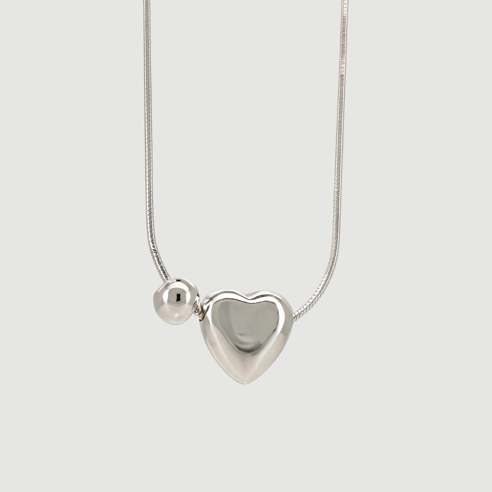 Amara Jewels sterling silver necklace with a heart charm and a small sphere.