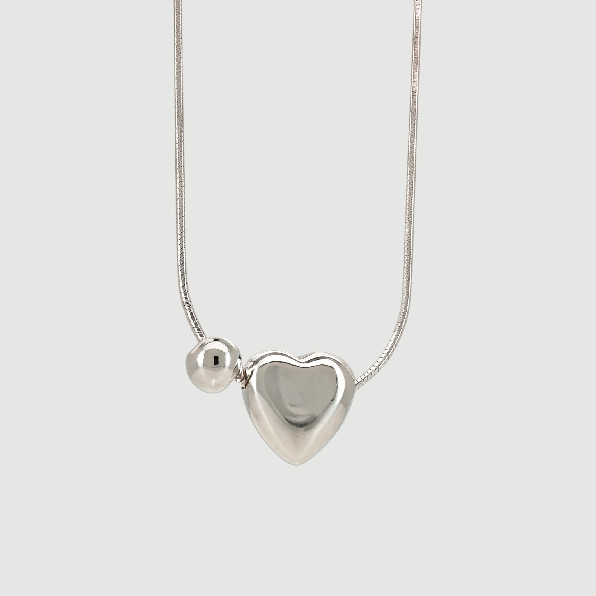 Amara Jewels sterling silver necklace with a heart charm and a small sphere.