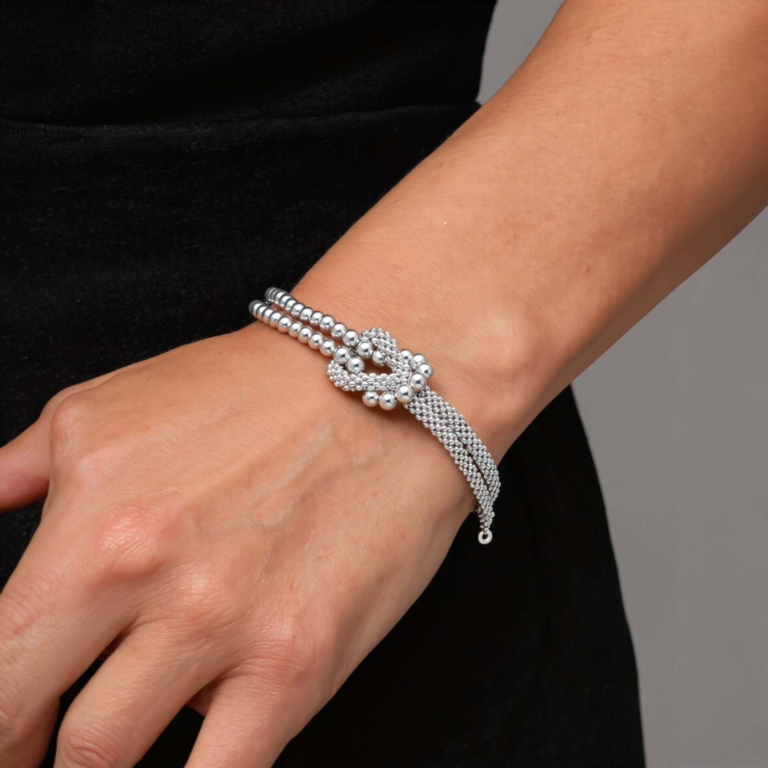 Amara Jewels sterling silver bracelet with multi-strand design and knot centerpiece, featuring polished silver beads.