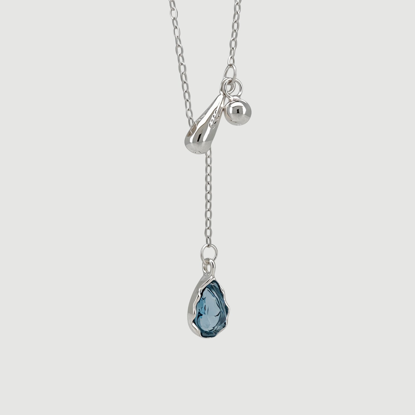 Amara Jewels sterling silver necklace with a blue teardrop gemstone pendant and silver charms.
