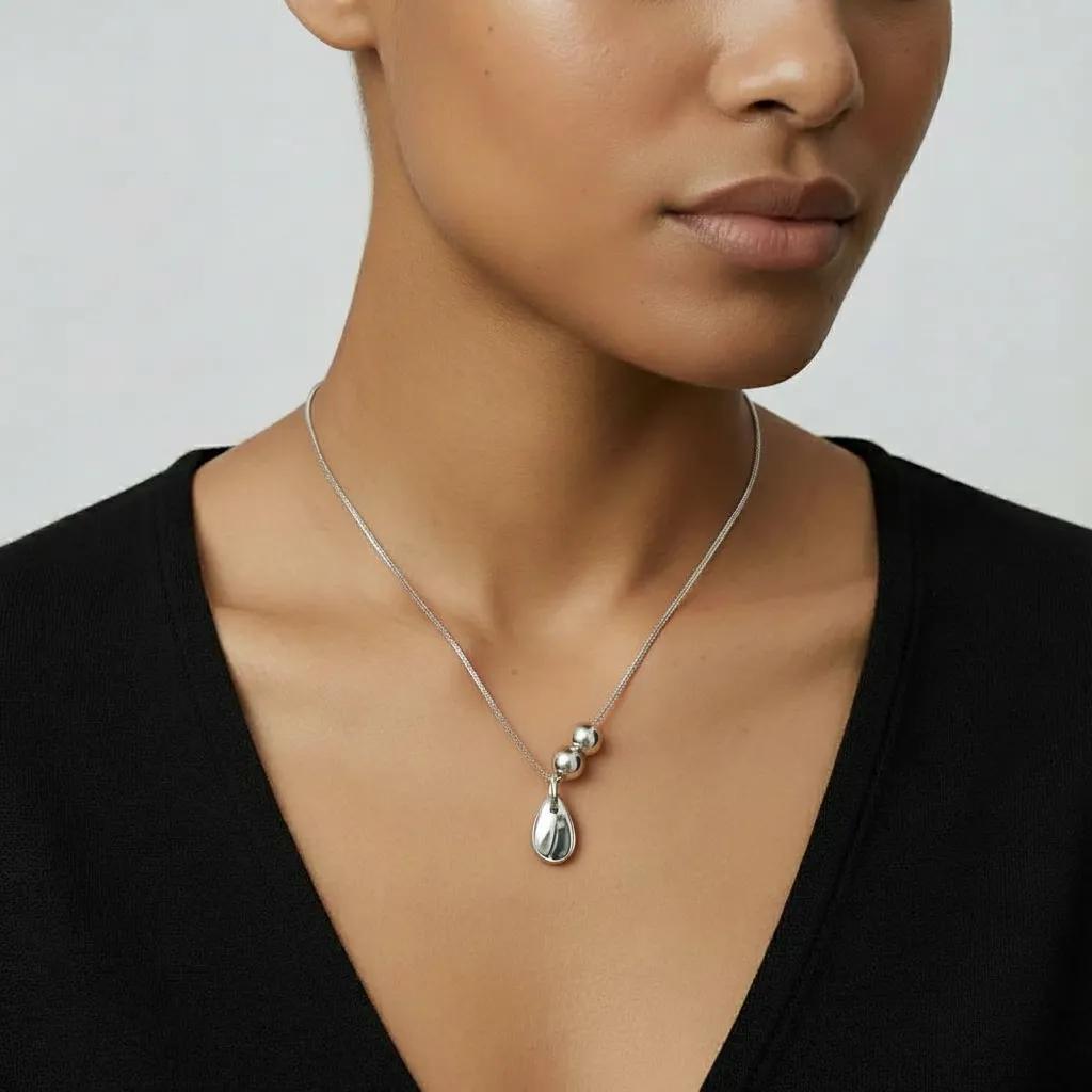 Amara Jewels polished sterling silver teardrop pendant necklace with two accent beads on a delicate chain.