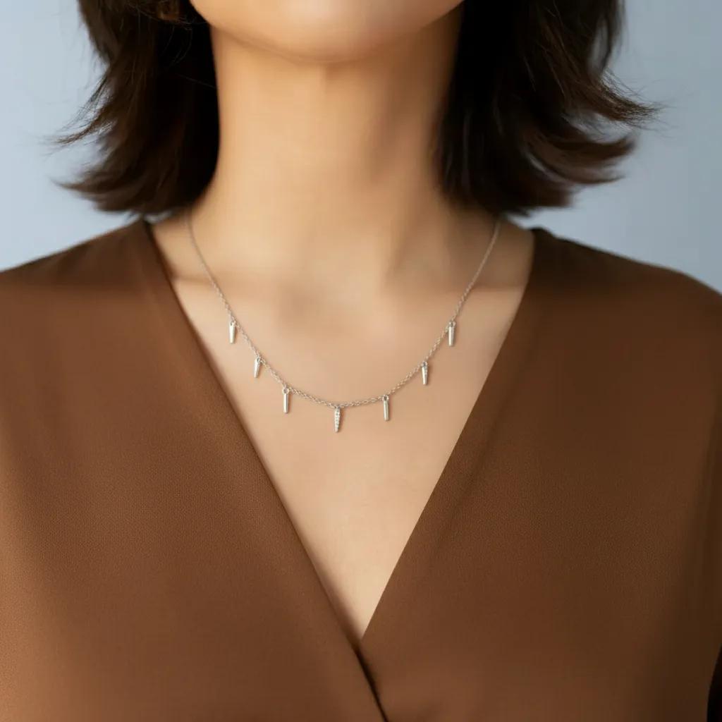Amara Jewels rhodium-plated sterling silver necklace with dangling spike charms and clear crystals.