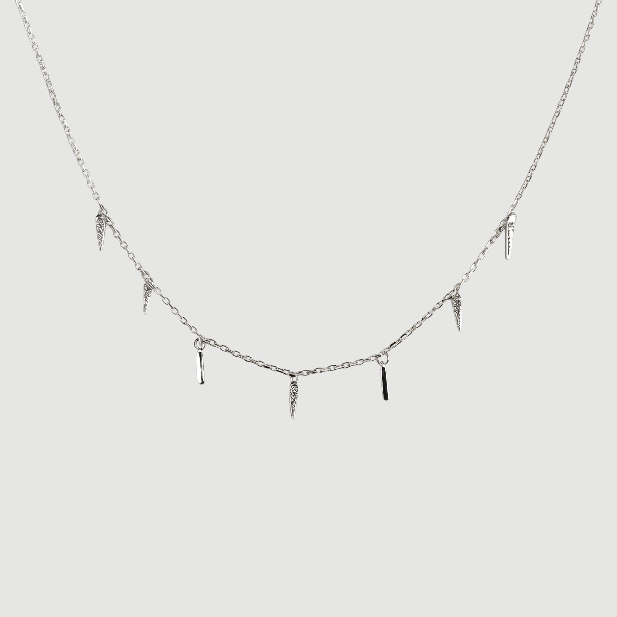 Amara Jewels rhodium-plated sterling silver necklace with dangling spike charms and clear crystals.