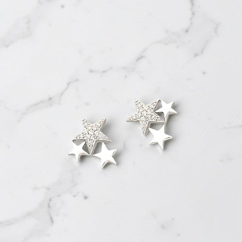 Amara Jewels rhodium-plated sterling silver stud earrings with a cluster of three stars, one paved with small crystals.