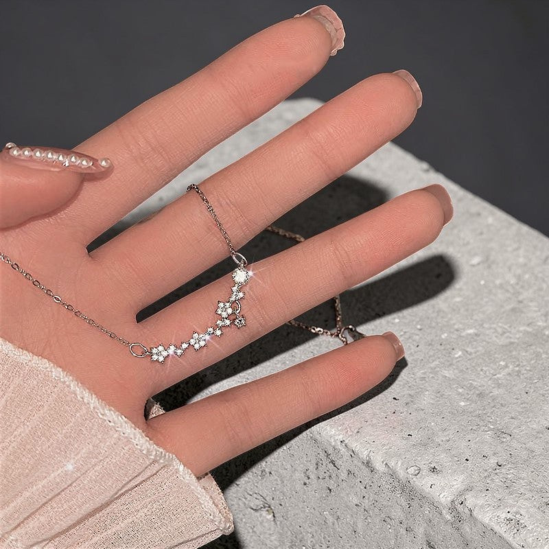 Amara Jewels 925 sterling silver necklace with delicate floral charms and sparkling cubic zirconia stones.