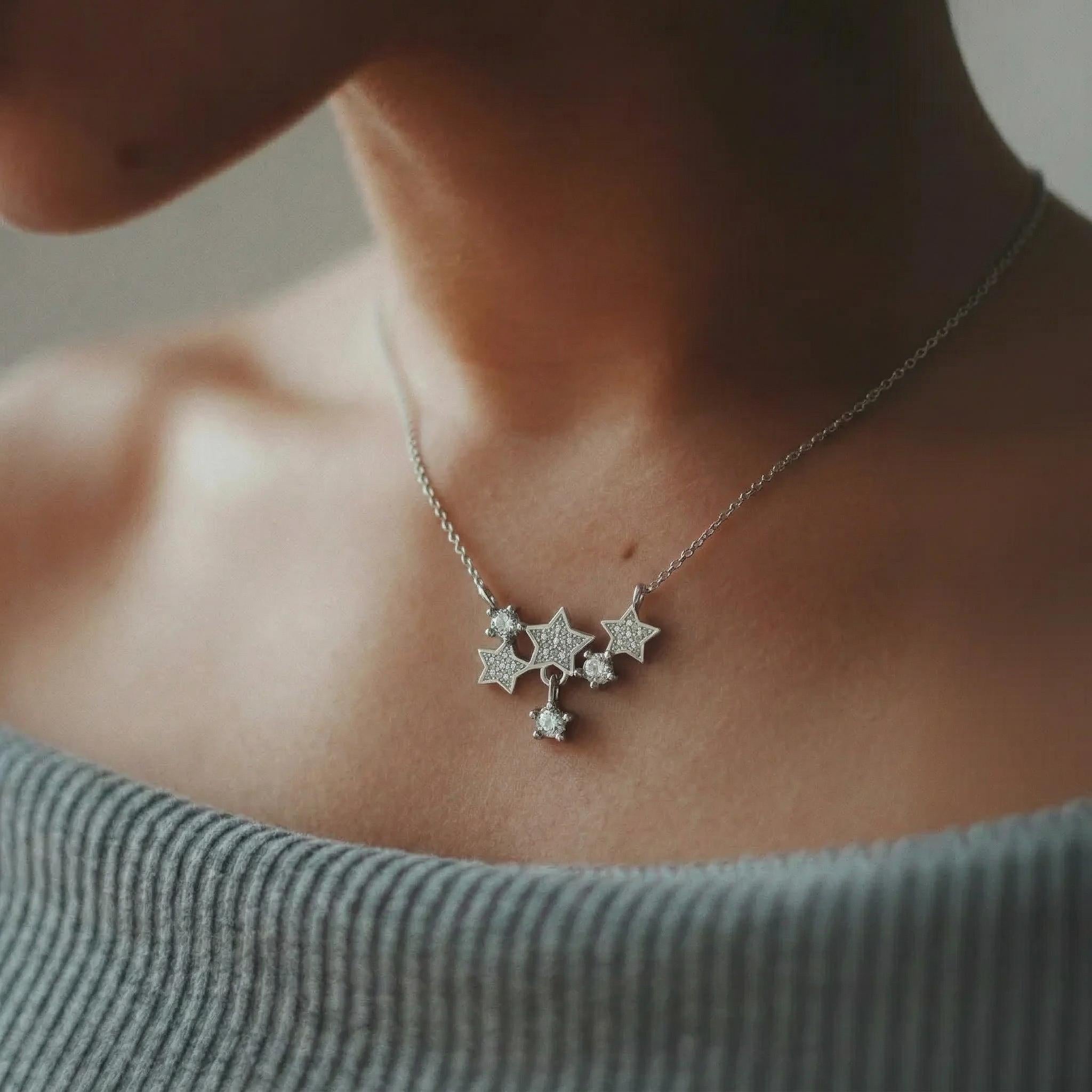 Amara Jewels sterling silver necklace with a cluster of sparkling star pendants adorned with crystals.